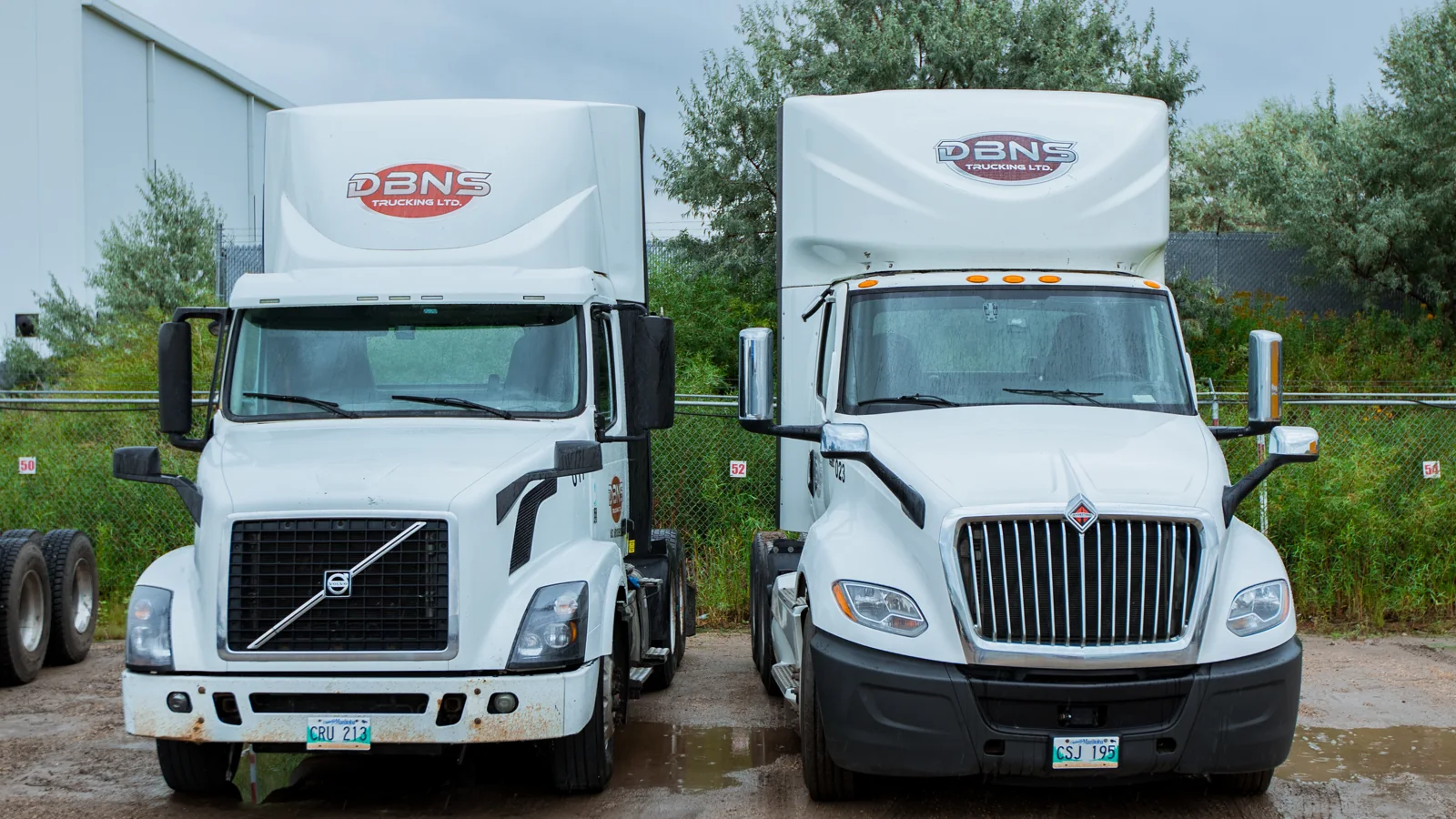 White Volvo and International DBNS trucks side by side